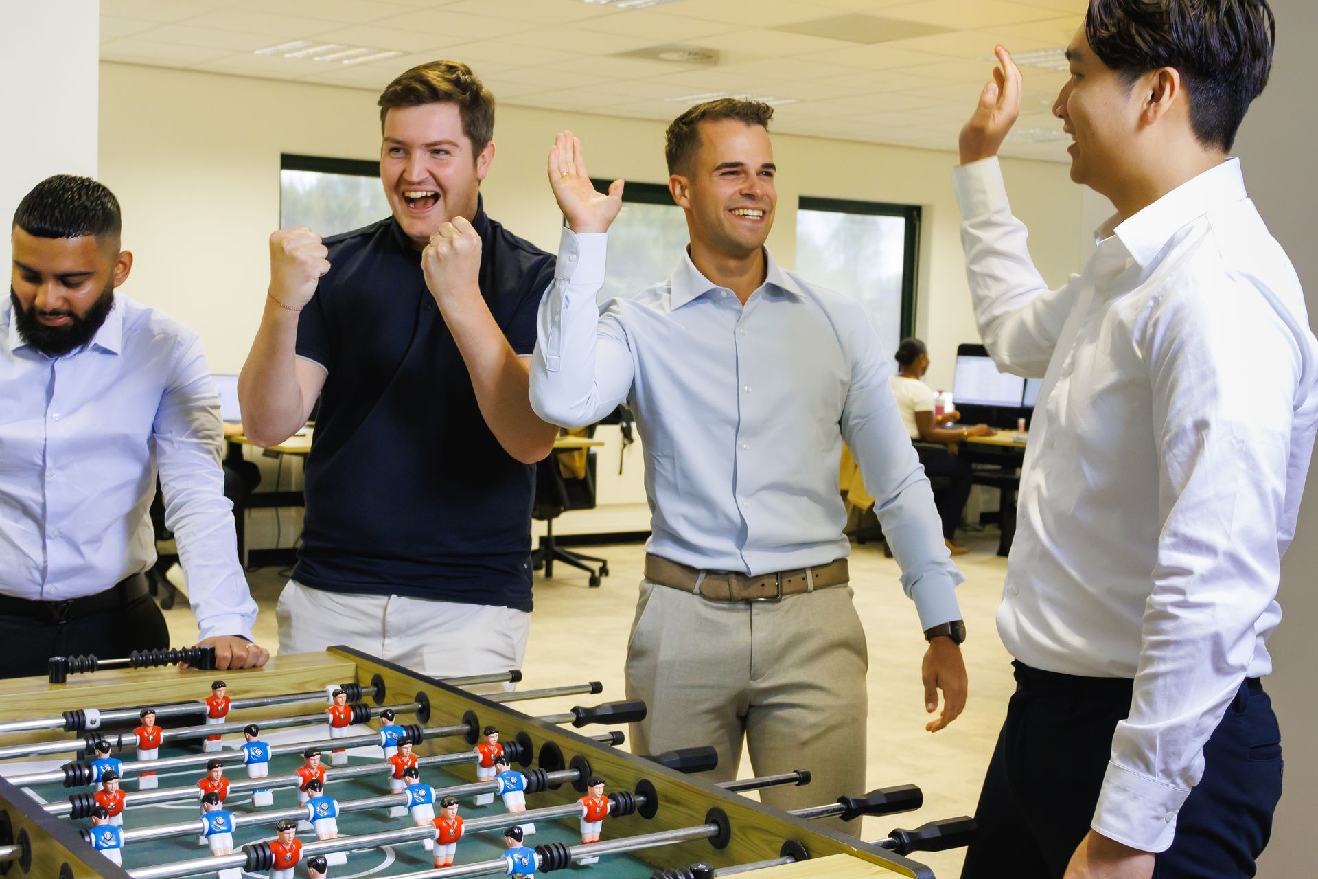 Collega’s van Publieke Sector Accountants die samen plezier hebben bij de tafelvoetbaltafel in een informele kantooromgeving. Collega’s van Publieke Sector Accountants die samen plezier hebben bij de tafelvoetbaltafel in een informele kantooromgeving.